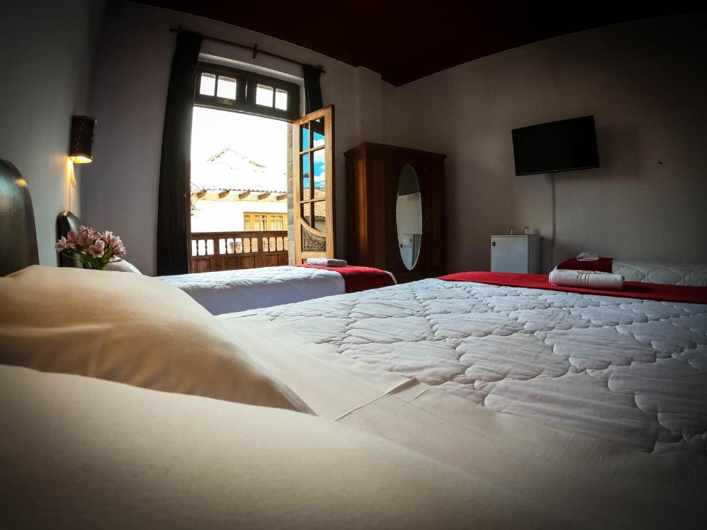 库斯科Casona Santa Catalina Cusco的窗户客房内的一张大白色床