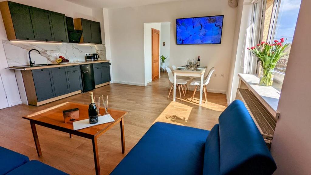 SzczedrzykSłoneczna Przystań - Apartament的客厅配有蓝色的沙发和桌子