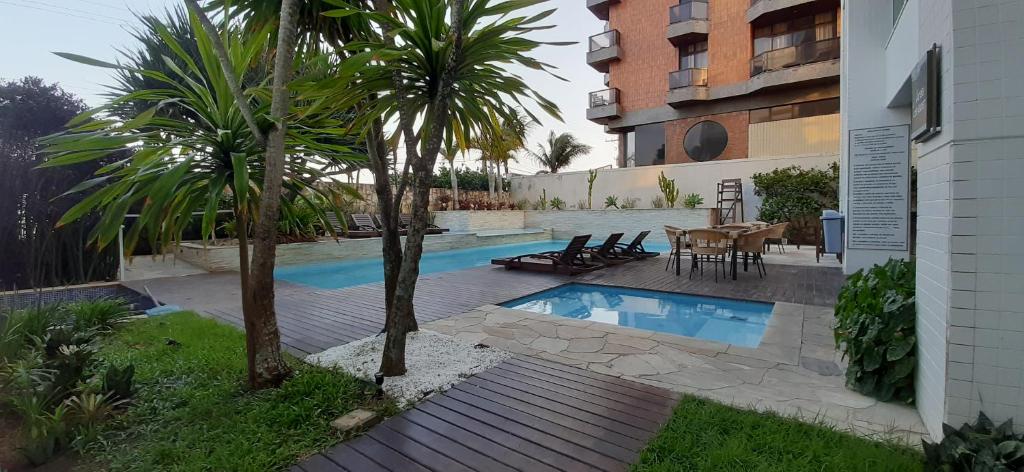 卡波布里奥Flat 404 Hotel Mandai的一个带桌子和两棵棕榈树的游泳池