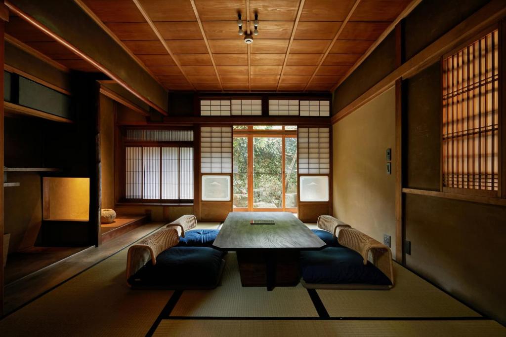 京都Umeyu no yado by YADORU KYOTO HANARE的一间带桌椅和窗户的用餐室