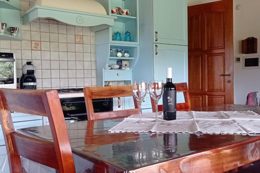 圣彼得罗镇Gli ulivi,casa tra Pula e Villa San Pietro Q3307的厨房配有带酒杯的桌子