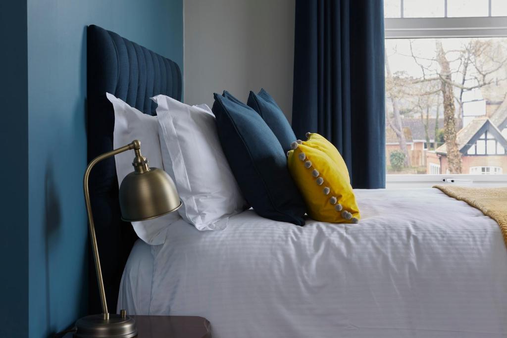托特兰米德哨兵酒店的一间卧室配有一张蓝色墙壁的床和一扇窗户