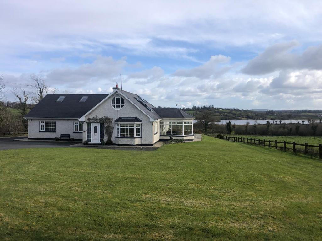 利特里姆Lough Aduff Lodge 5 minutes from Carrick on Shannon的白色的房子,有大绿色庭院