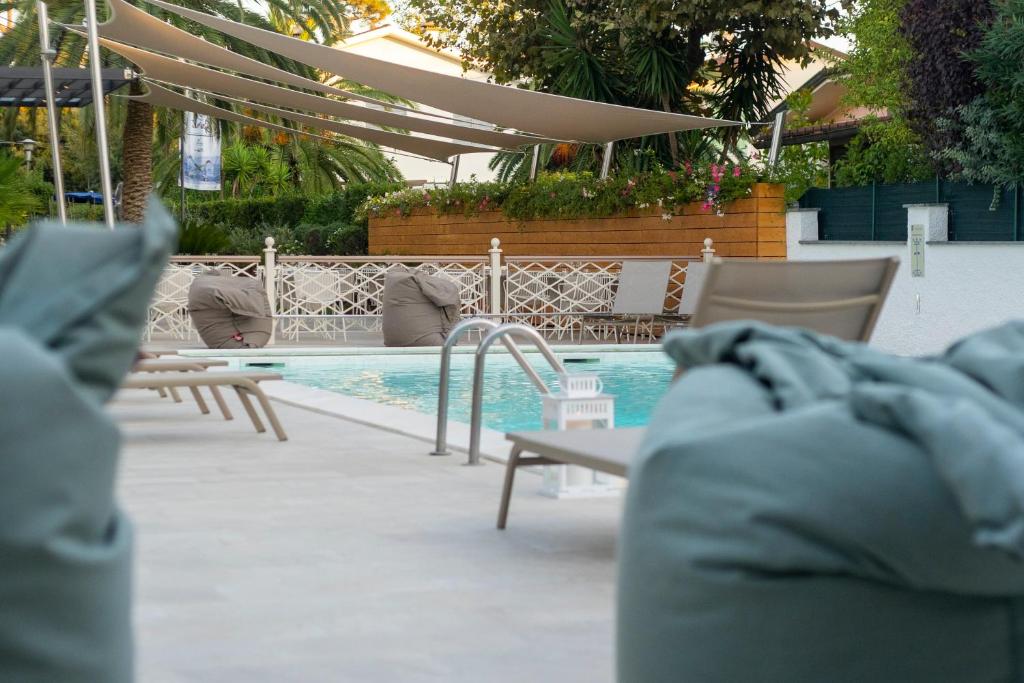 马尔米堡塔拉贝拉酒店的一个带桌椅的游泳池和一个游泳池