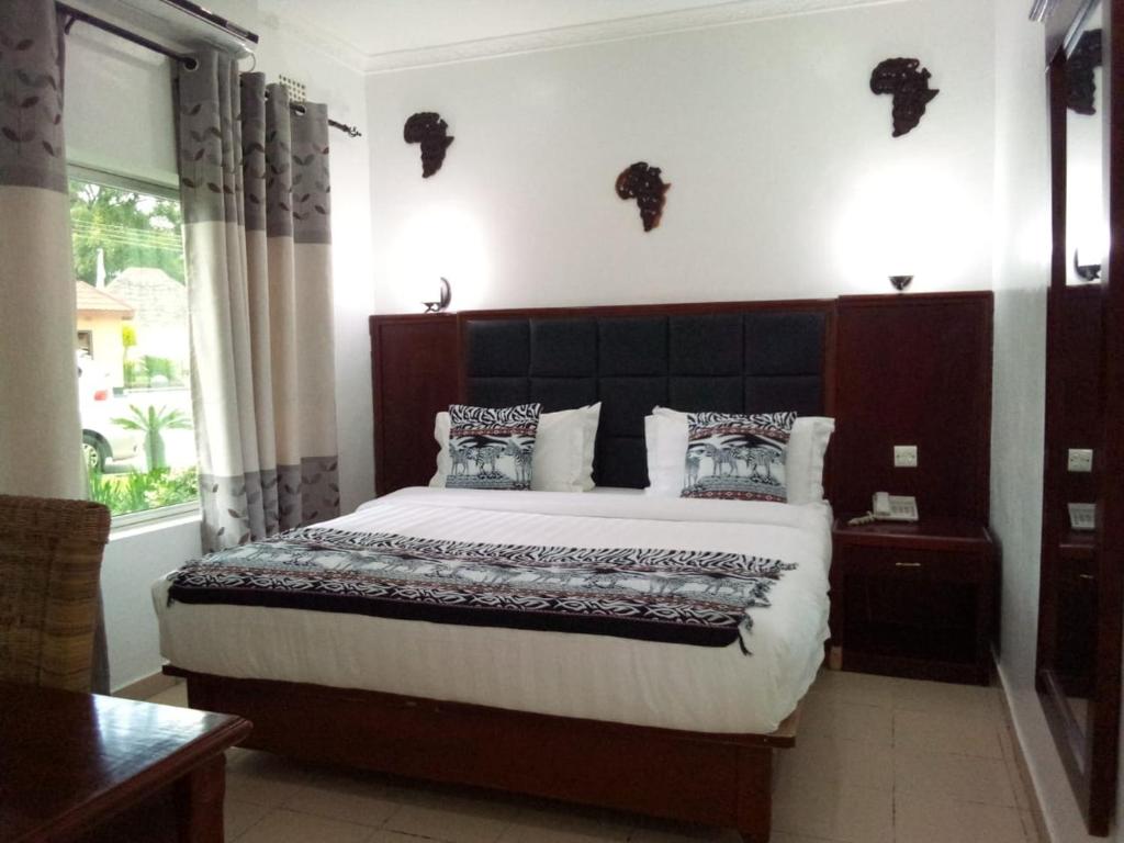 卢萨卡米卡山林小屋的一间卧室设有一张大床和一个窗户。