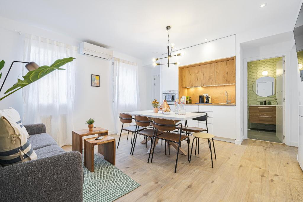 马德里Vallecano Apartments by Olala Homes的厨房以及带桌椅的起居室。