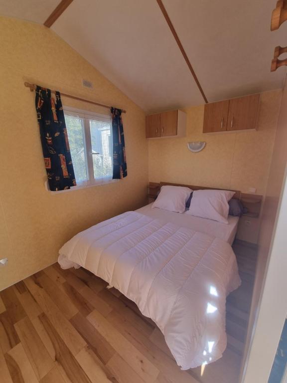 拉康提内勒La belle Perrochoise 13 mobilhome的卧室配有一张大白色床和窗户