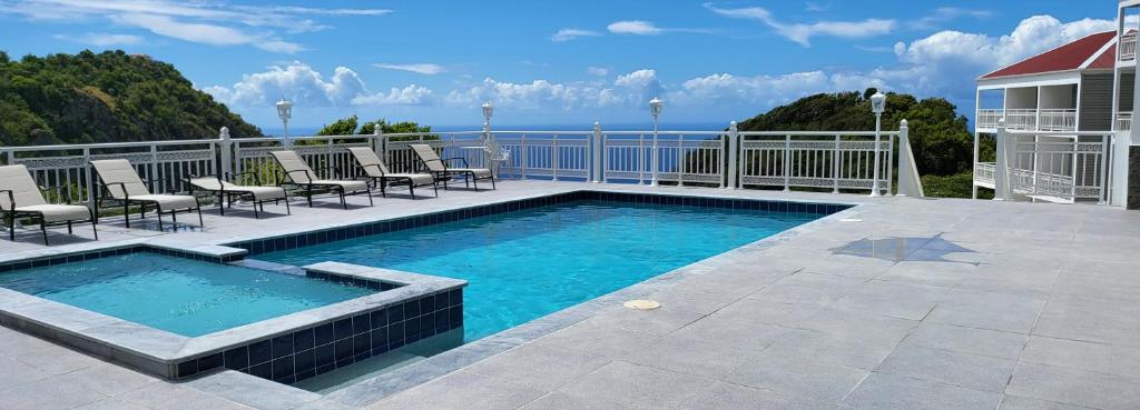 温沃德赛德Saba Arawak Hotel的一个带椅子的庭院和大海上的游泳池