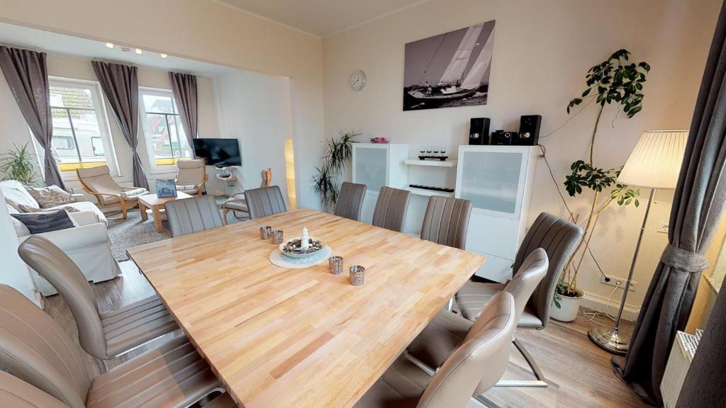 拉博埃Haus Friedrichstr. 16的用餐室以及带木桌和椅子的客厅。