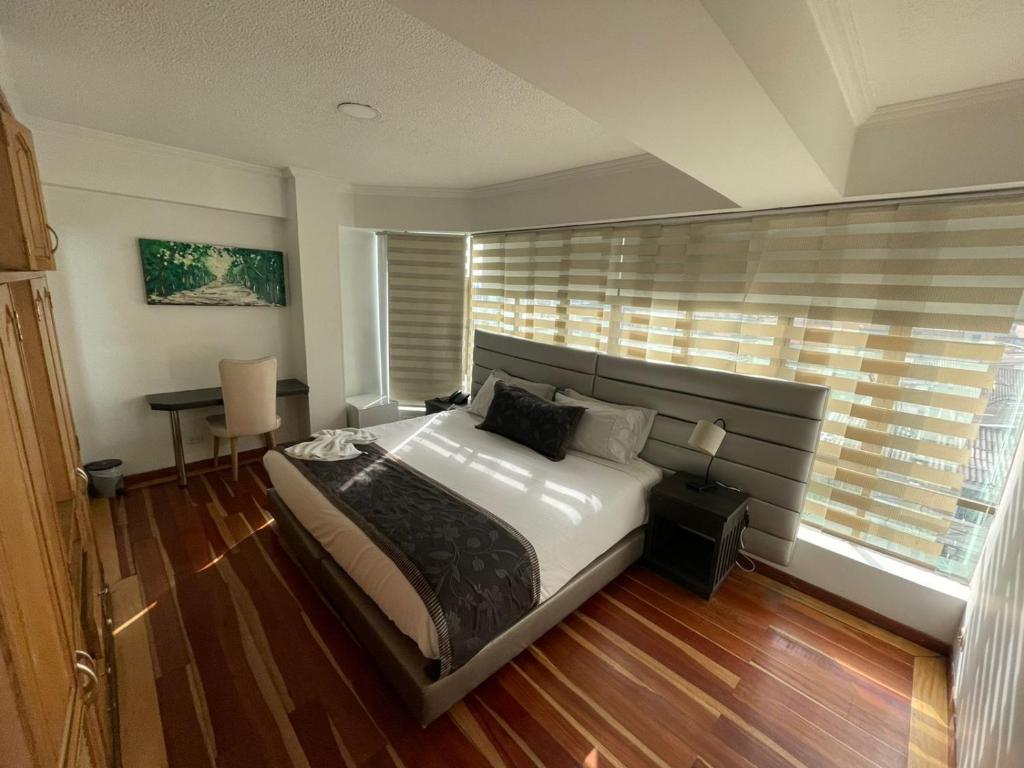 波哥大Hotel Airport Travel的一间卧室配有一张床、一张书桌和一个窗户。
