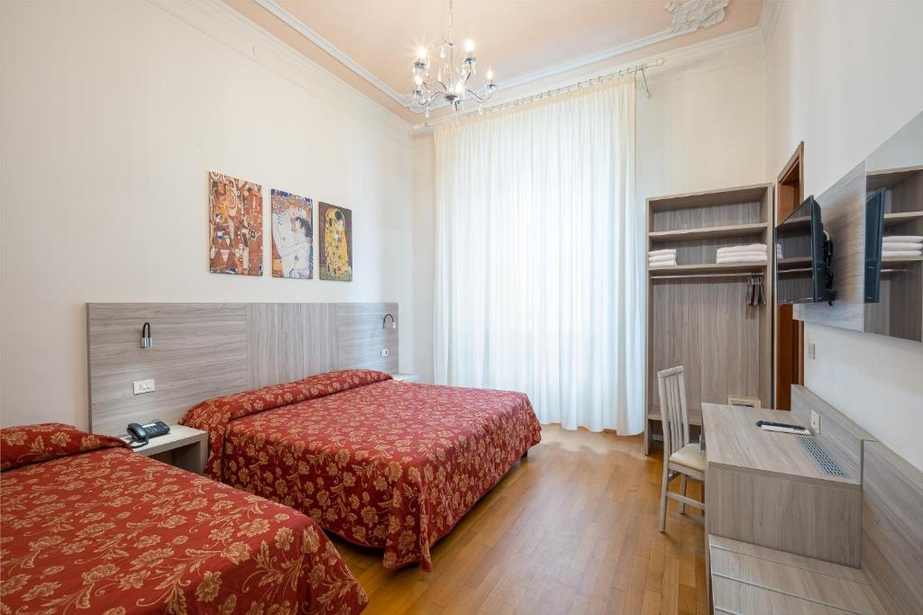 佛罗伦萨百合酒店的酒店客房设有两张床和一张桌子。
