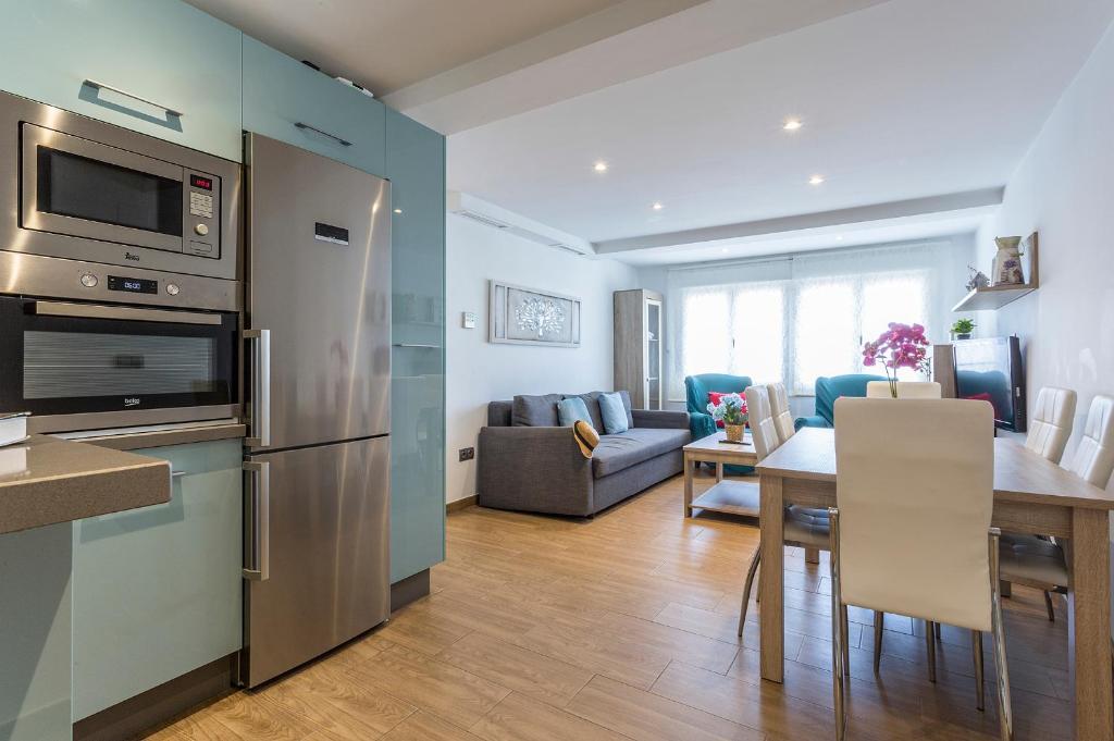 加的斯Apartments Vistas Mar Bahia的厨房以及带不锈钢冰箱的起居室。