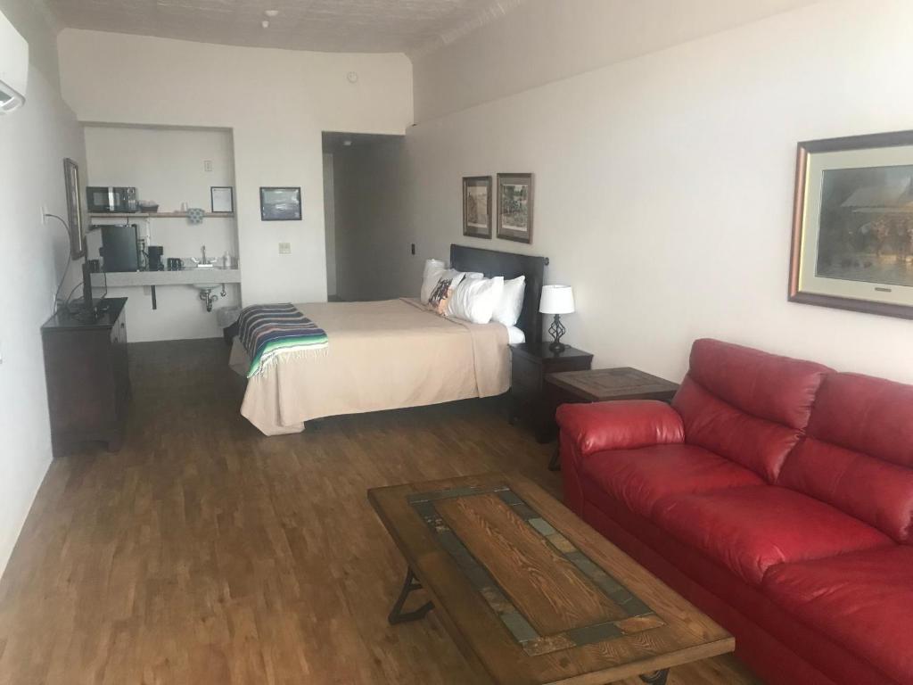 汤姆斯通Katie's Cozy Suites的客厅配有床和红色沙发