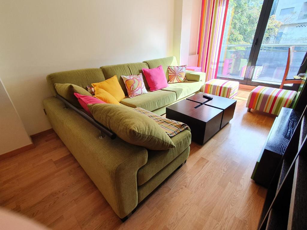 尼格兰PISO EN EL CENTRO DE NIGRAN CERCA DE PLAYA AMERICA的客厅配有带色彩缤纷枕头的绿色沙发