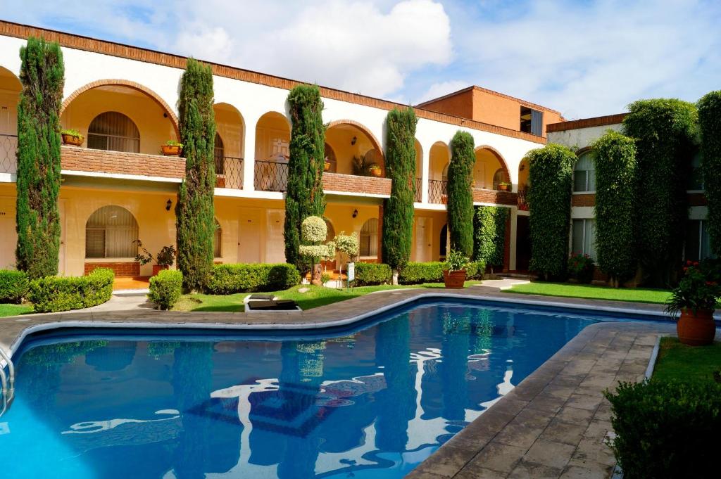莫雷利亚维拉德尔索尔酒店及套房的建筑前带游泳池的庭院