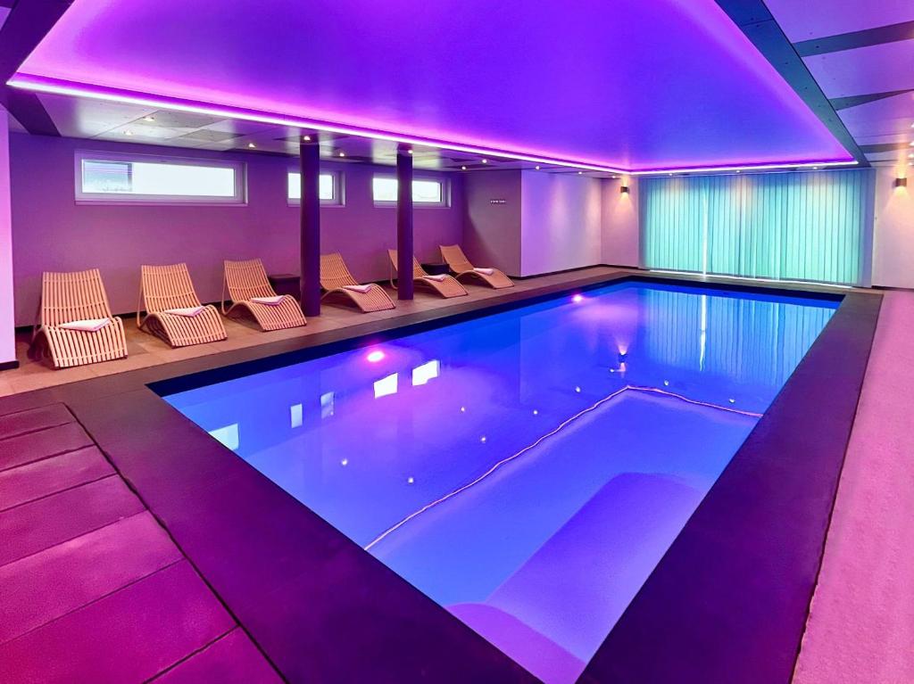 比特亨巴赫Villa Natica的一座房子里带紫色灯的游泳池