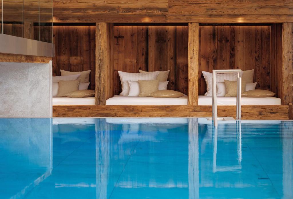 霍伊塞尔恩ADLER HÄUSERN Gourmet & Spa Hotel的房屋旁设有游泳池的房间
