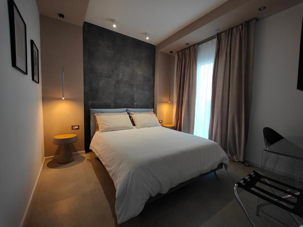 马达莱纳Capricci di Vento - Design Guest House的卧室设有一张白色大床和一扇窗户。