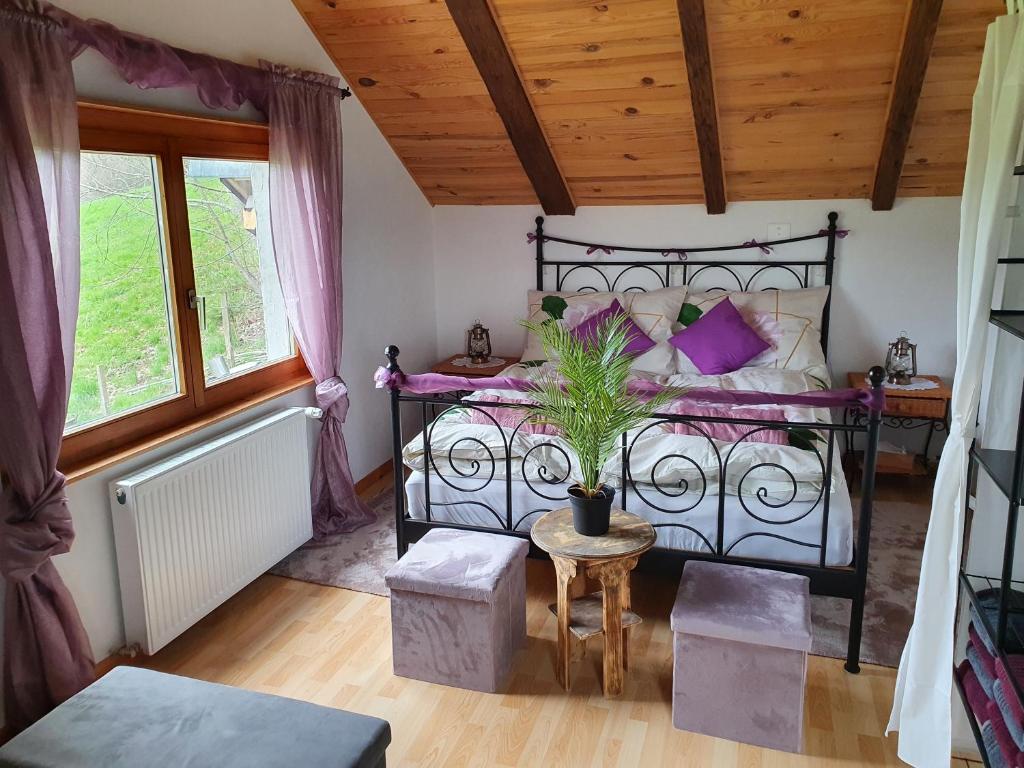 TavannesGîte de la Motte的一间卧室配有一张黑色床和紫色枕头