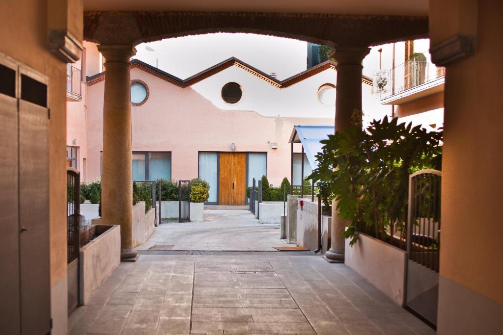 米兰Easy Milano - Rooms and Apartments Navigli的一条小巷,通往一座带木门的建筑