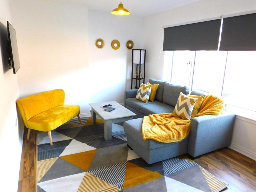 汉密尔顿Newly refurbished 2 bedroom apartment close to station and local amenities的客厅配有沙发和椅子