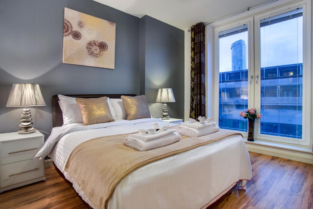 伯明翰Inners City Apartments -On Suites的一间卧室配有一张大床和两条毛巾