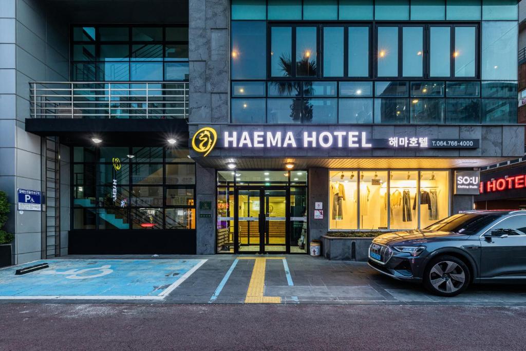 济州市Hotel Haema的停在一个山羊酒店前的汽车