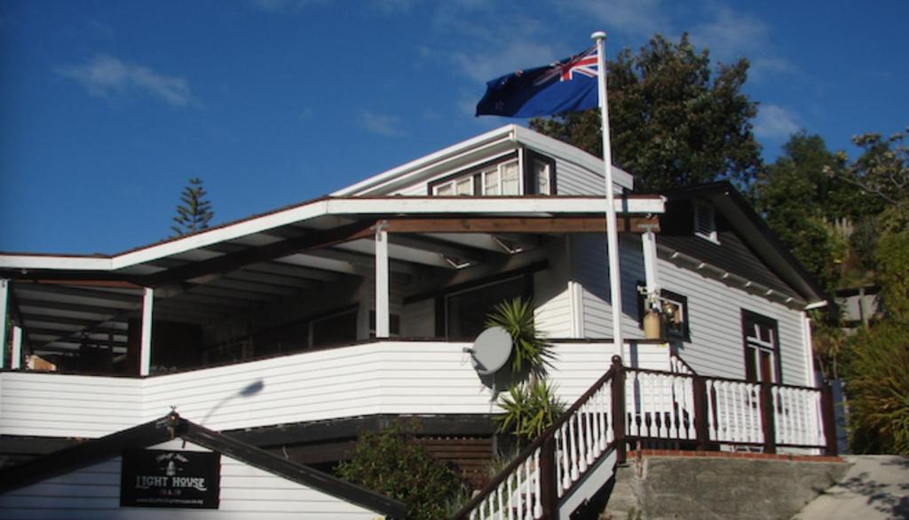 纳皮尔Bluff Hill Lighthouse B&B的前面有旗帜的房子