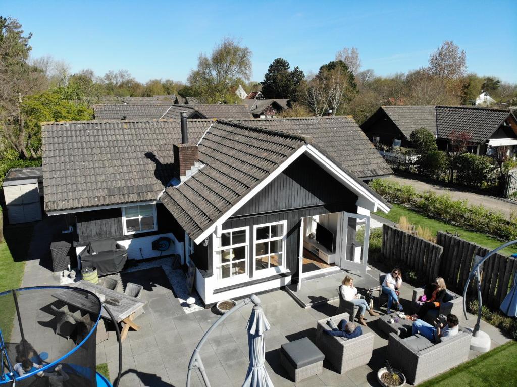 奥德多普Heerlijke bungalow op 350 meter vanaf het strand!的房屋的顶部景色,人们坐在庭院里