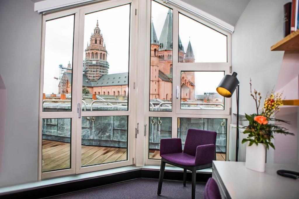 美因茨Erbacher Hof, Bistum Mainz的客房设有带紫色椅子的窗户,享有美景。