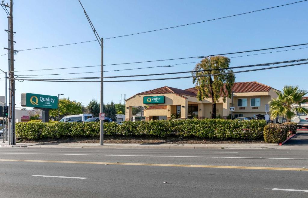 长滩Quality Inn Long Beach - Signal Hill的一条空的街道,有加油站和建筑物