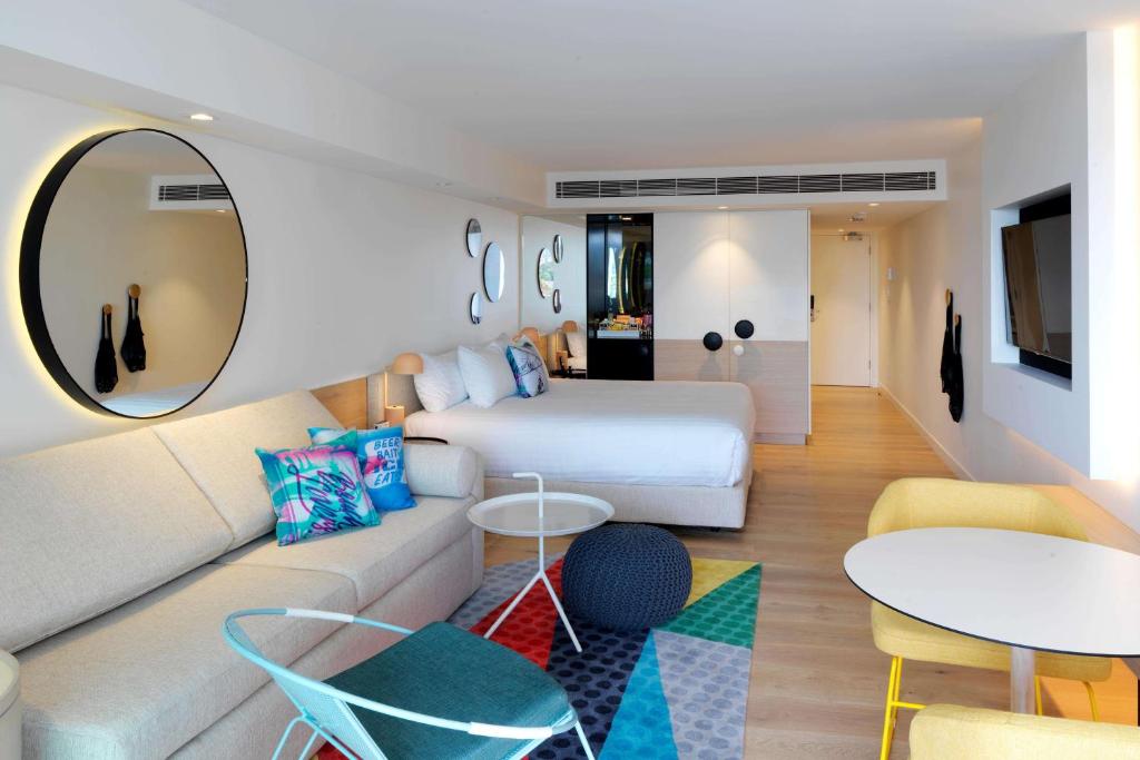 悉尼邦迪QT公寓式酒店的酒店客房,配有床和沙发