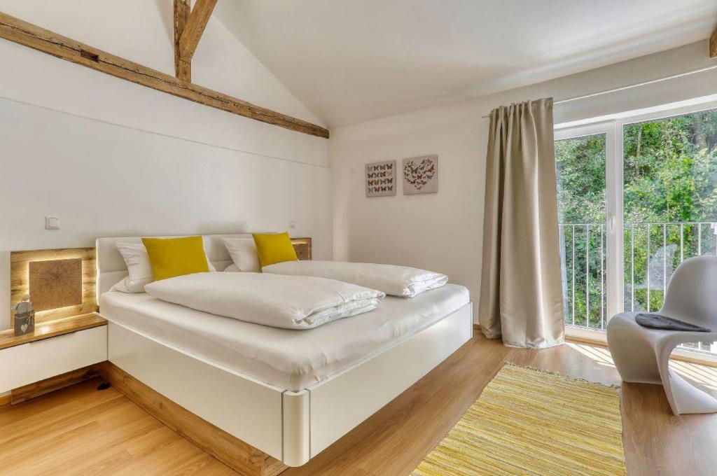 德拉塞尔斯里德Das Bachhaus的一间卧室配有白色床和黄色枕头