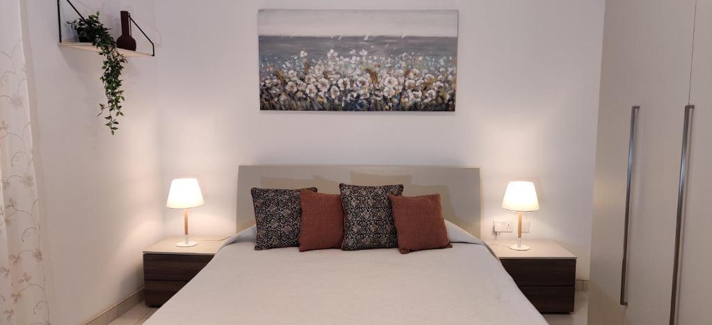马尔萨什洛克Lorenza Letting Maisonette的一间卧室配有一张大床和两盏灯