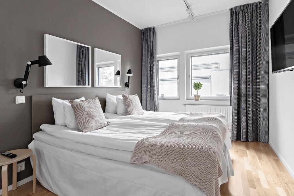 斯德哥尔摩Forenom Hotel Kista的卧室配有一张带白色床单和枕头的大床。