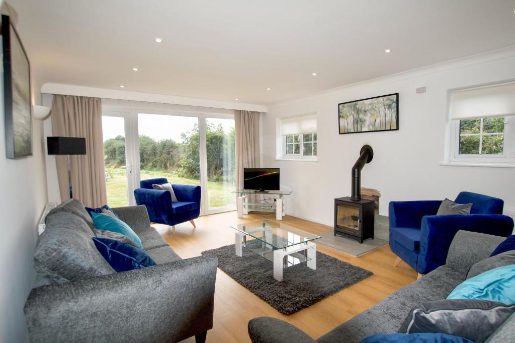 Kirby CrossSpacious 5 bed in the countryside, close to Frinton-On-Sea的客厅配有蓝色的沙发和电视