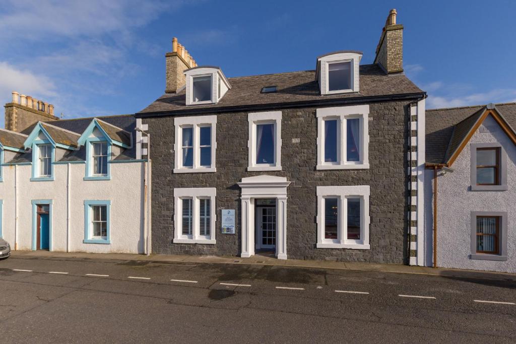 波特帕特里克Carlton House Portpatrick的街道上带白色窗户的大型砖屋
