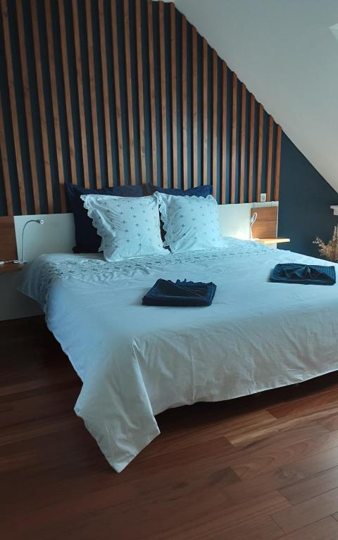 格鲁瓦Kerlobek Albacore的卧室配有一张白色大床和木制床头板