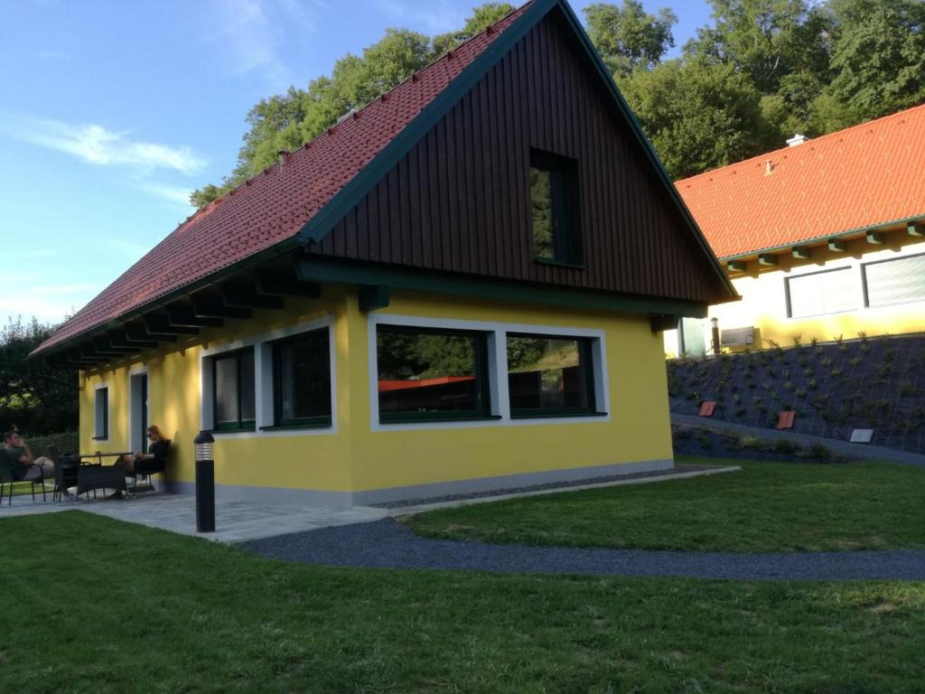 克勒希Chalet Auszeit的一间黄色的小房子,有黑色的屋顶