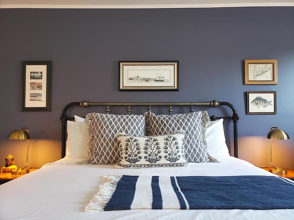 巴港Little Fig Hotel的一间卧室拥有蓝色的墙壁,配有一张带枕头的床。