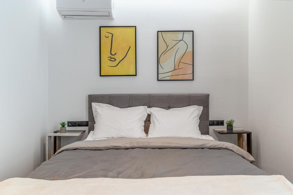 雅典Athena Studio in Gazi的卧室配有一张墙上三幅照片的床