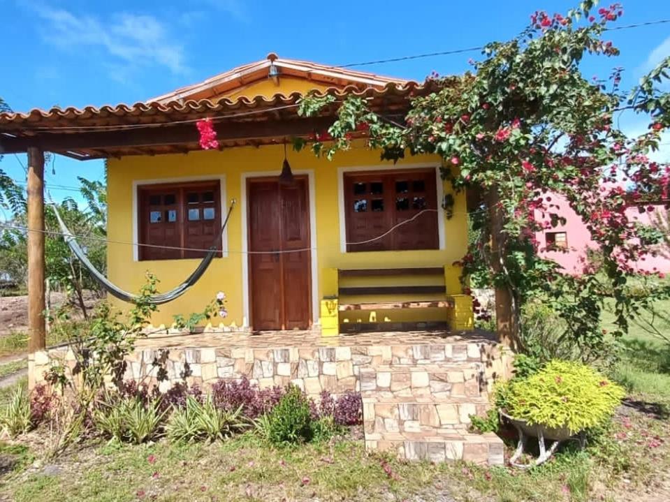 伊比科阿拉Pousada Serra Aquarela - Mini casas的黄色的房屋,有红色的屋顶