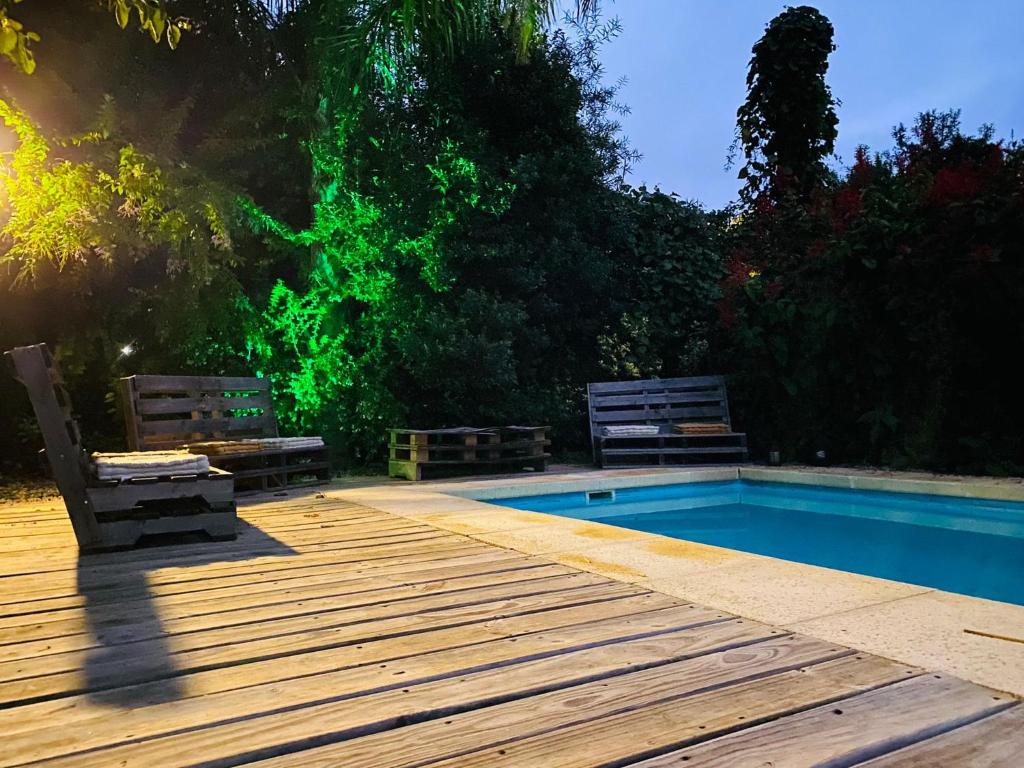 科洛尼亚-德尔萨克拉门托CASA MIA bednbreakfast的木甲板旁的带2个长椅的游泳池