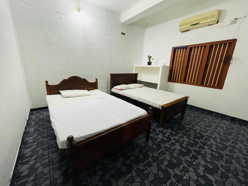 贾夫纳Jaffna RR Holiday Home Non AC的客房设有两张床和窗户。