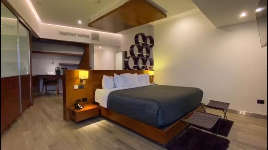 普埃布拉Sonata Hotel Puebla Angelópolis Distrito Sonata的一间卧室配有一张床和一张书桌