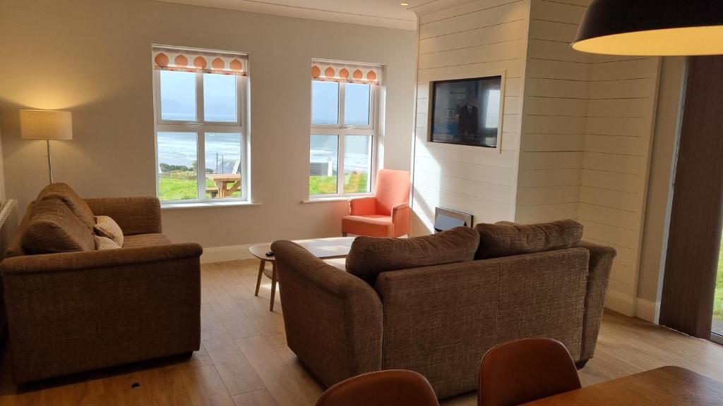 因奇Inch Beach Cottages的客厅配有2张沙发、1张桌子和2把椅子