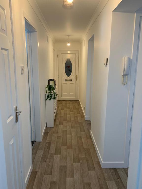 邓弗里斯Dumfries Apartment的走廊设有白色的墙壁和木地板