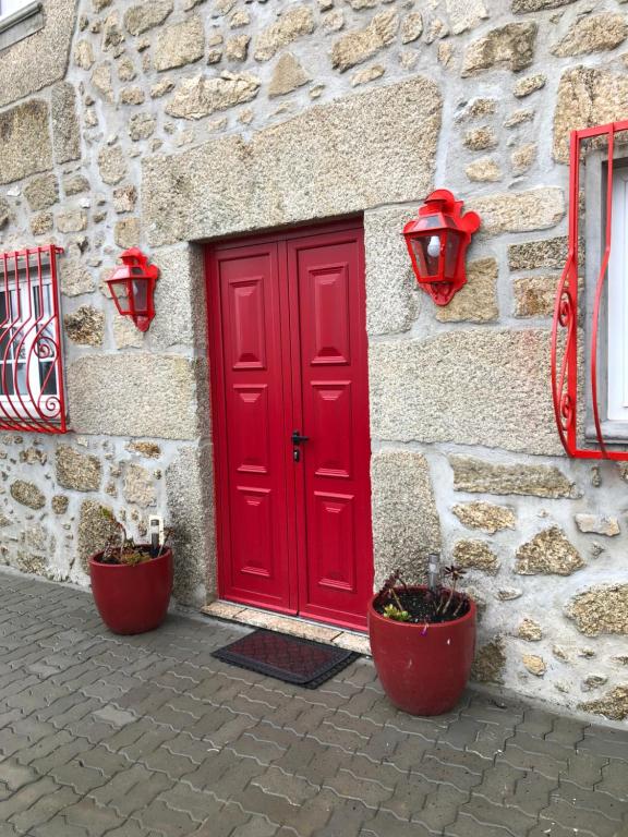 MeloCasa Dos Cabritos的石头建筑一侧的红色门