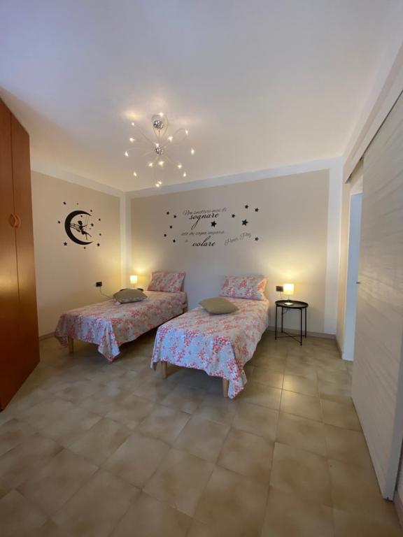 奥梅尼亚Intero alloggio :Casa D D Nuova aperturaHost Rosi的一间卧室设有两张床,墙上有书写