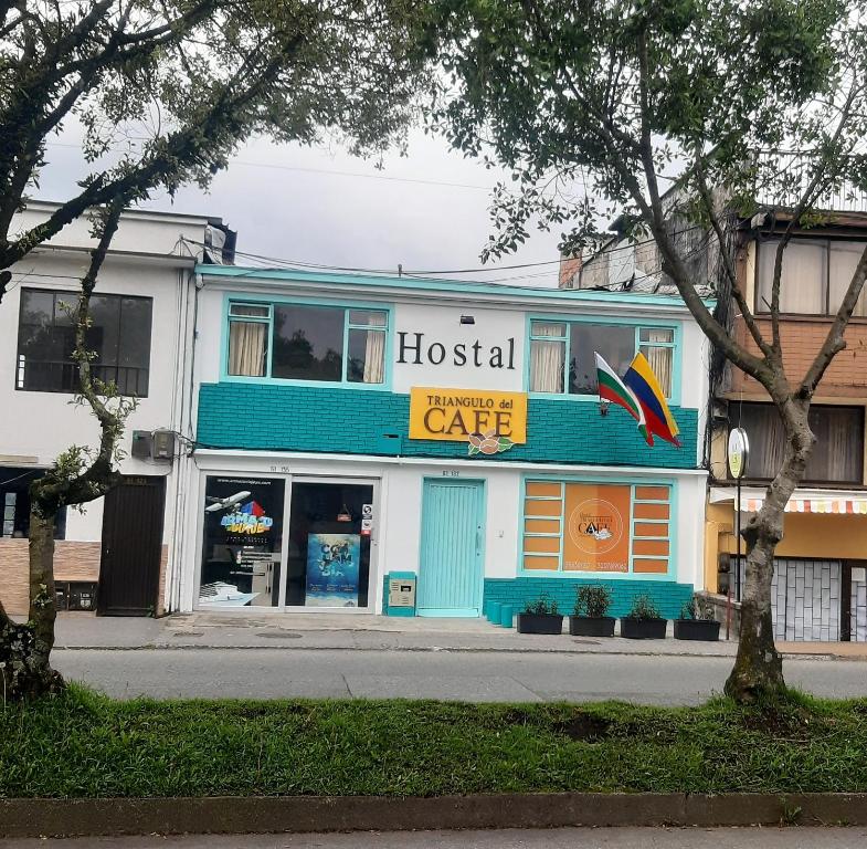 马尼萨莱斯Hostal Triangulo del Café的街上有医院咖啡馆的建筑